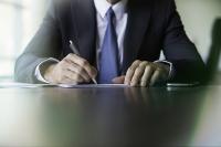 Homme en train de signer un document