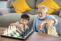 Un senior joue aux échec avec un jeune garçon