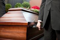 Deux hommes portent un cercueil