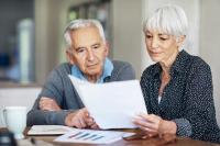 Un homme et une femme retraités lisent un document