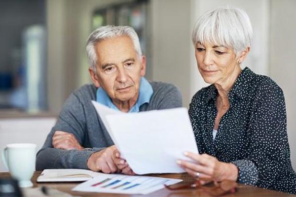 Un homme et une femme retraités lisent un document