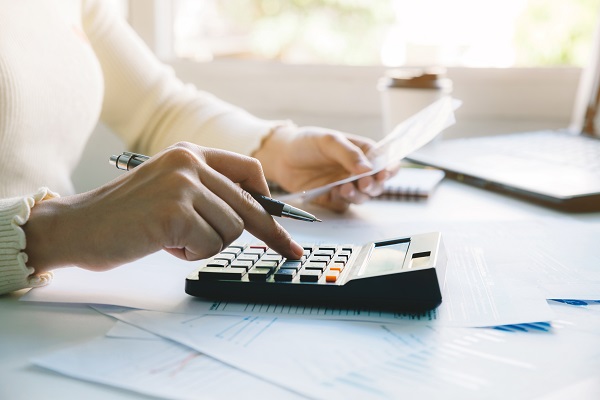 Une femme calcule les impots avec une calculatrice dans un bureau moderne