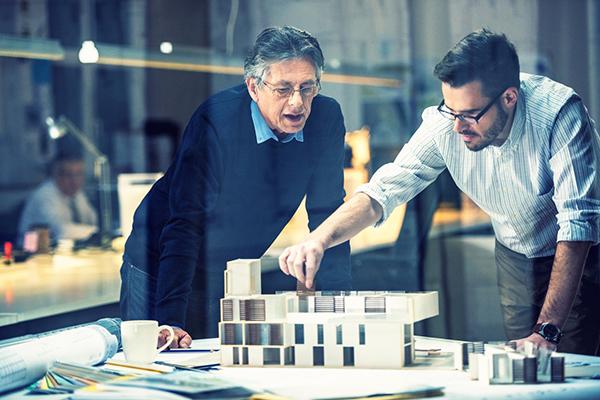 deux architectes travaillent sur une maquette dans un bureau