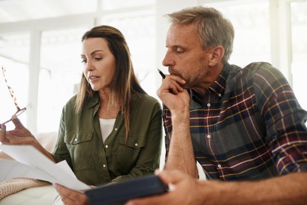 Un couple fait ses comptes en utilisant une calculatrice