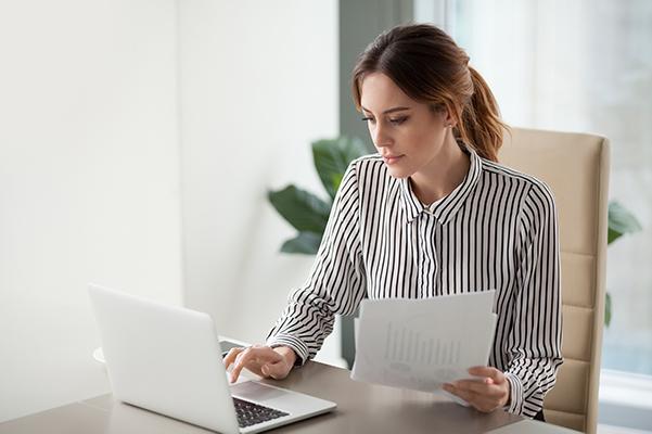 une jeune femme travaille sur son ordinateur portable sur un bureau