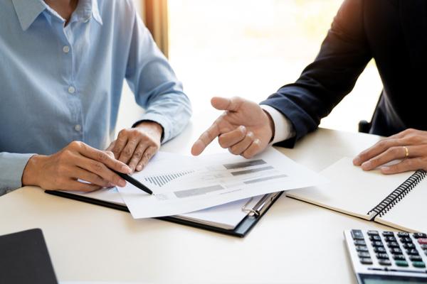 gros plan sur un conseiller et un client qui regardent un contrat