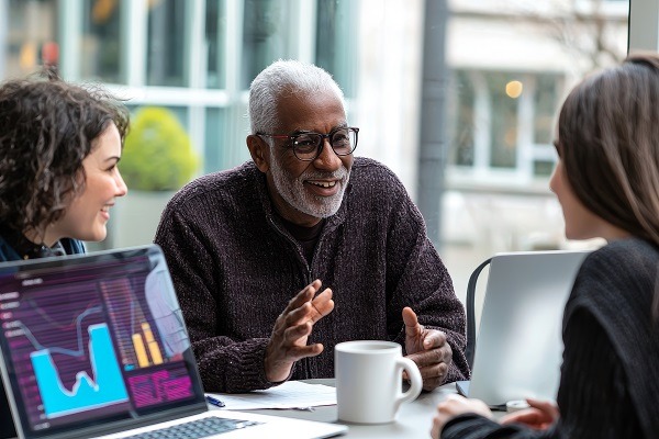 Le vieil homme discute des plans de retraite et des options d'assurance-vie avec le banquier professionnel, qui offre des conseils financiers dans un bureau moderne.